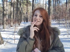 redhead smokes in the forest